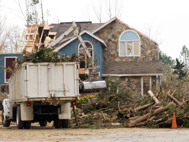 Storm cleanup truck and piled tree branches