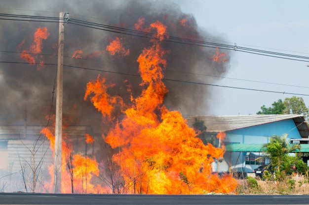 Large roadside fire with thick black smoke