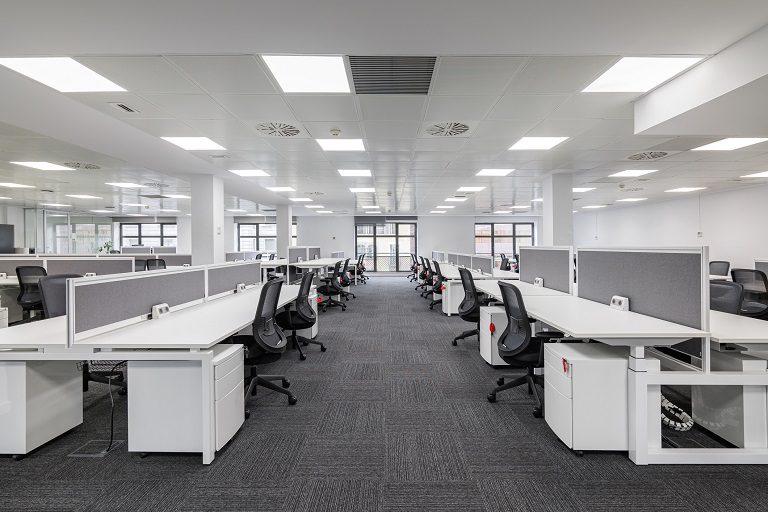 Empty modern open-plan office with rows of desks